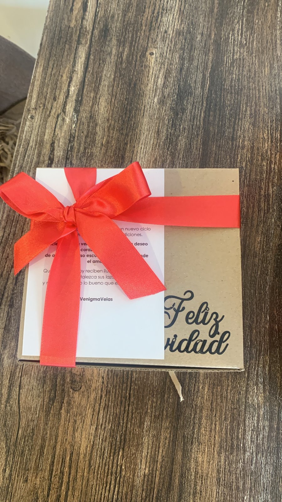 Caja kraft cerrada con moño rojo y tarjeta